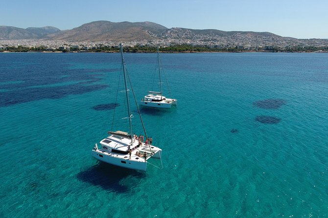 Athens Private Luxury Catamaran Cruise with Traditional Greek Meal and BBQ - First swimming stop, towels and open-water views
